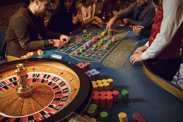 Hand of a croupier on a roulette whell in a casino.