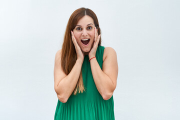 Fototapeta premium Happy young woman making the surprised gesture on a white background.