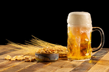Draft beer in glasses and peanut on wooden surface