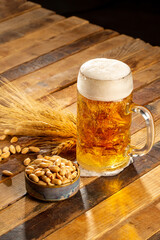 Draft beer in glasses and peanut on wooden surface
