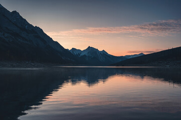 Fototapeta na wymiar Sunrise on rocky mountains with colorful sky on Medicine Lake, Jasper national park