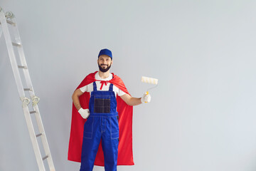 Happy home repair worker engaged in house renovation on gray background. Young contractor holding...