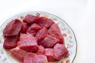 veal meat on a decorated dish over a white background