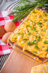 Delicious potato casserole with egg and cheese on a gray wooden background