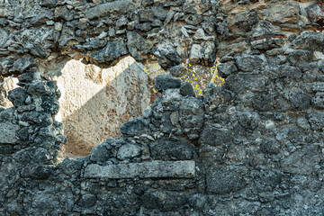 Black volcanic stonewall with opening gap
Hole in the wall that shows background