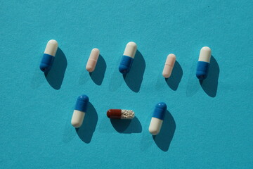 Blue and white pills on blue background.