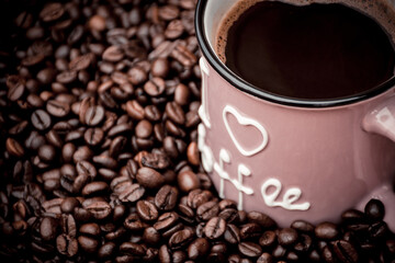 a mug filled with black coffee and beans in the background