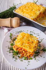 Delicious potato casserole with meat and cheese on a white wooden background
