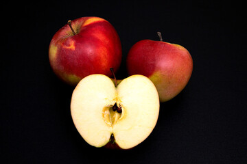 red apple and piece on black background