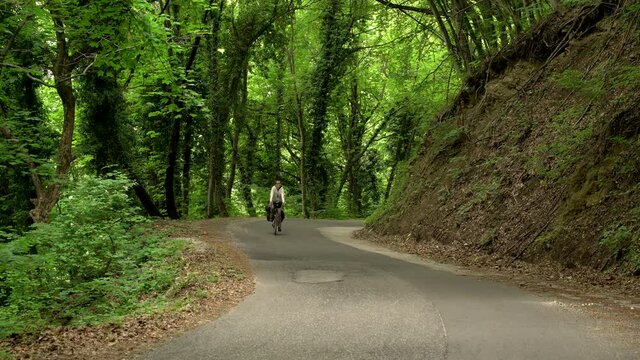 Man cycling through calm road, Zumberak national park, Croatia.