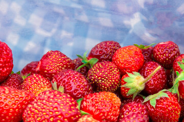 Strawberry berries close-up on a blue blurry background, selective focus, copy space. The concept of organic food, organic gardening and diet.
