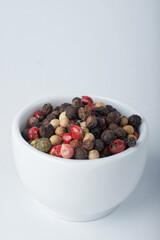 A mixture of peppers. Black, white, red polka dots. Isolated on a white background. The selected sharpness