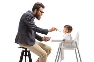 Father feeding baby in a feeding chair