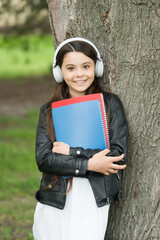 Audio lesson. Happy kid listen to audio file at tree. Little child wear audio headphones. Listening to audio podcast. New technology. Modern life. Hi-Fi sound. Listen to English everyday