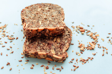 Sliced whole grain bread rye with seeds flax, sunflower, pumpkin and sesame.Healthy food, eco-friendly natural products. Fresh bread on a pink background.