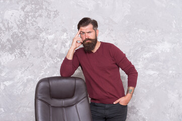 Trendy outfit perfect for his style. Brutal hipster stand at office chair. Bearded man in casual style. Business style. Fashion and style. Casual menswear. Mens wardrobe