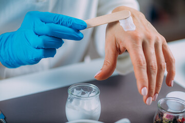 Female Pharmacist Testing Cream Scent in Laboratory © Microgen