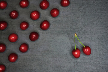 Naklejka na ściany i meble composition of cherries on a black stone background 