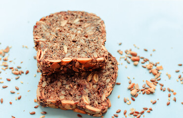 Sliced whole grain bread rye with seeds flax, sunflower, pumpkin and sesame.Healthy food, eco-friendly natural products. Fresh bread on a pink background.