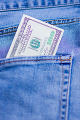 100 dollar bill sticking out from a blue jeans pocket. American banknote. Business concept