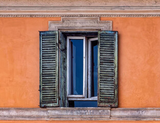 Rome Italy, vintage house decorated window on vibrant orange wall
