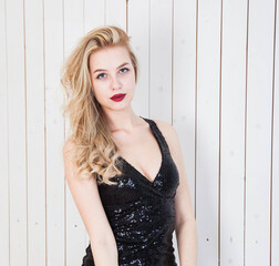 portrait of a young woman with white hair and bright makeup in a black short dress