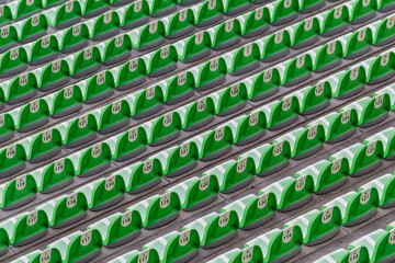 Fototapeta premium diagonal lines of rows of green plastic seats inside a soccer stadium
