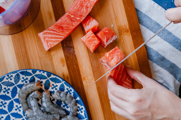 Woman hands chopping a salmon fillet