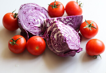 sliced red cabbage and ripe tomatoes on a white background