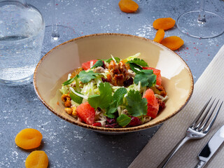 Fresh salad with grilled chicken, vegetables, nuts and grapefruit