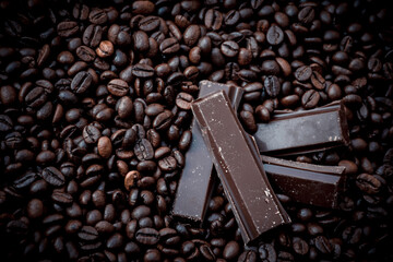 sweet and tasty dark chocolate bars surrounded by coffee beans