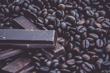 sweet and tasty dark chocolate bars surrounded by coffee beans
