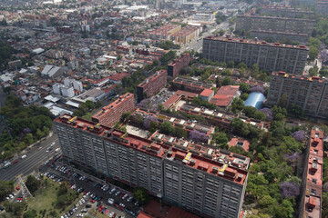 Aerial view of Tlatelolco apartment residential complex in Mexico City with green areas with booming jacarandas