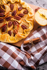 crispy apple galette with pecans on a rustic wooden background