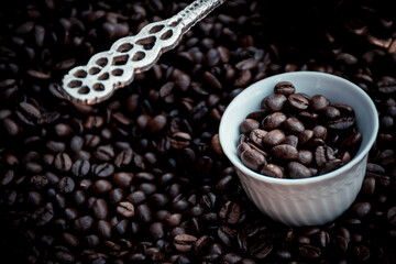 Fototapeta premium coffee pot and cup filled and surrounded by coffee beans