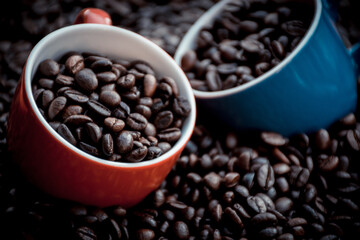 Fototapeta premium red and blue coffee cups filled and surrounded by coffee beans