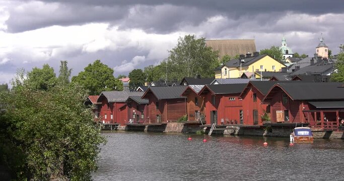 4K video of Porvoo vintage red wooden buildings, Porvoo Cathedral, yachts and boats in Porvoonjoki River near town center on sunny summer day in Finland, northern Europe
