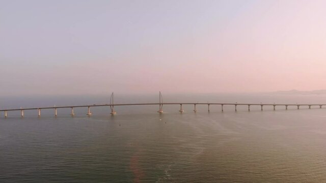 Panning aerial shot of famous Hong Kong - Zhuhai - Macau Bridge during golden hour