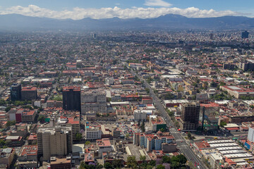 Fototapeta na wymiar Aerial view of Mexico City center toward the south, with a mountain range in the back