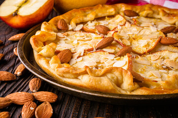 crispy apple galette with almonds on rustic wooden background