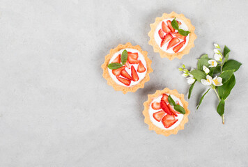 Dessert tartlets with cottage cheese cream and fresh strawberries on a light gray background top view copy space