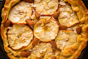 crispy apple galette with almonds on rustic wooden background
