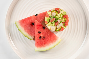 Ceviche cocktail in circle with watermelon wedges.
Elegant fish cocktail served in a round shape along fresh fruit.
