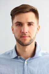 Fototapeta premium Close up of handsome gentleman in blue shirt looking at camera with serene expression