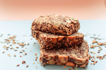 Sliced whole grain bread rye with seeds flax, sunflower, pumpkin and sesame.Healthy food, eco-friendly natural products. Fresh bread on a pink background.