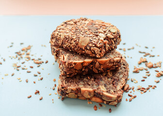 Sliced whole grain bread rye with seeds flax, sunflower, pumpkin and sesame.Healthy food, eco-friendly natural products. Fresh bread on a pink background.