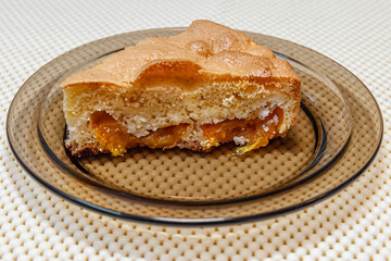 a piece of homemade sponge cake with apricots and cottage cheese on a glass plate