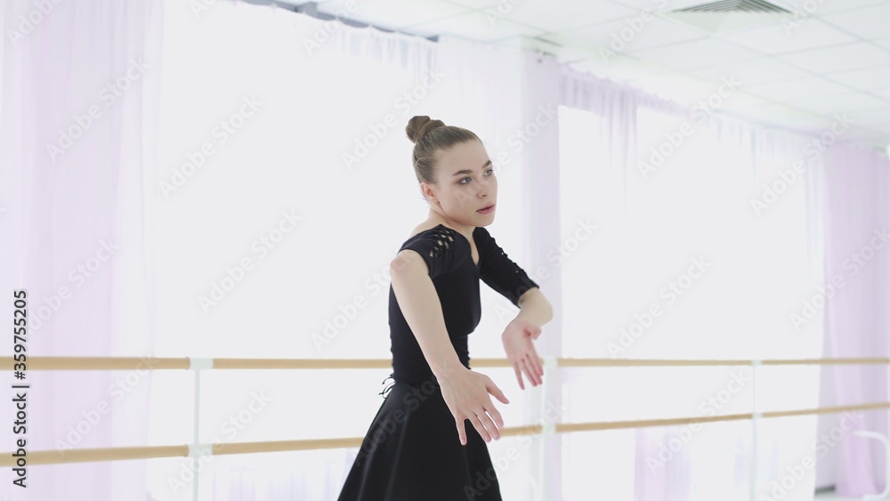 Wall mural young ballerina makes beautiful movements with her hands.