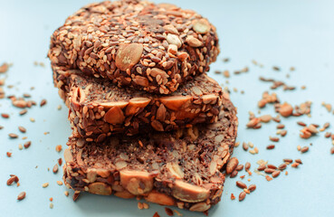 Sliced whole grain bread rye with seeds flax, sunflower, pumpkin and sesame.Healthy food, eco-friendly natural products. Fresh bread on a pink background.