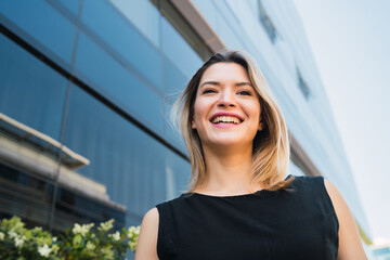 Business woman standing outside office buildings.